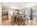 Bright dining area featuring wood cabinets, floors, island, and a sliding door to the outdoor space at 3803 Churchman Woods Blvd, Indianapolis, IN 46203