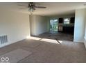 Bright living room featuring carpet, neutral walls, and ample sunlight, creating a warm and inviting space at 3805 Windstar Way, Columbus, IN 47203