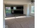 Spacious living room with carpet, open layout and natural light filtering through the windows and sliding glass door at 3805 Windstar Way, Columbus, IN 47203