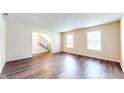 Bright living room with wood floors, neutral walls, and staircase access at 3916 Jekyll Ct, Indianapolis, IN 46237