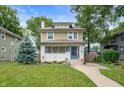 Inviting home with a manicured lawn, lush landscaping, and a charming blue front door at 4040 Carrollton Ave, Indianapolis, IN 46205
