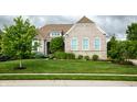 Charming single-Gathering home boasts a lush green lawn and meticulously maintained landscaping at 4420 Hickory Ridge Blvd, Greenwood, IN 46143