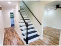 Interior staircase with white risers and black treads with a wood handrail at 5130 Navajo Ct, Columbus, IN 47203