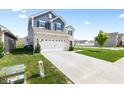 Exterior view showcasing the long concrete driveway and attached two-car garage at 5848 Sheffield Ln, Whitestown, IN 46075