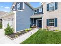 Charming entrance with blue door, decorative plants, and a cozy bench at 5848 Sheffield Ln, Whitestown, IN 46075