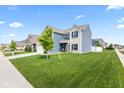 Landscaped front yard with lush green grass surrounding a modern two-story home at 5848 Sheffield Ln, Whitestown, IN 46075