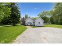 Exterior shot reveals a gravel driveway, a cozy deck with seating, and a brick chimney at 6450 N State Road 75, North Salem, IN 46165