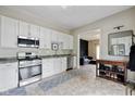 Bright kitchen boasts white cabinets, stainless steel appliances, and an adjacent living area at 6450 N State Road 75, North Salem, IN 46165