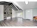 Bright living room featuring a stone fireplace, wood floors, exposed beams, and ample natural light at 7414 Mendenhall Rd, Camby, IN 46113