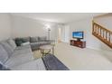 Spacious living room with neutral carpet, a large sectional sofa, and a staircase at 764 Port Dr, Avon, IN 46123