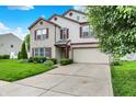 Attractive two-story home with brick and vinyl siding, complemented by a green lawn and driveway at 9001 Harrison Run Ct, Indianapolis, IN 46256