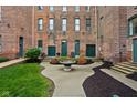 Charming courtyard featuring a decorative fountain, lush greenery, and access to brick building entrances at 970 Fort Wayne Ave # 303, Indianapolis, IN 46202
