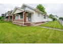 Charming single-story home with green lawn, white siding, and welcoming front porch with brick accents at 1065 36Th St, Indianapolis, IN 46208