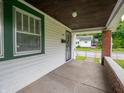 Inviting covered porch with brick accents, concrete flooring, and views of the surrounding neighborhood at 1065 36Th St, Indianapolis, IN 46208