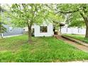 Charming home featuring an inviting front porch, complemented by mature trees, and an access ramp at 1106 W 4Th St, Anderson, IN 46016