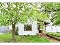 Charming home featuring an inviting front porch, complemented by mature trees, and an access ramp at 1106 W 4Th St, Anderson, IN 46016