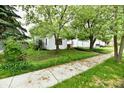 Inviting front yard with mature trees shading the home, complemented by a sidewalk leading to the property at 1106 W 4Th St, Anderson, IN 46016