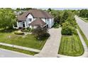 Elegant home featuring a pristine lawn, professional landscaping, and a spacious driveway at 14020 Brookstone Dr, Carmel, IN 46032