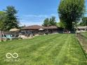 Spacious backyard featuring a pool, patio with seating, partial privacy fence, and a lush green lawn at 1425 Winding Trail Cir, Greenwood, IN 46142