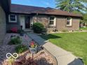 Charming brick home featuring a well-manicured lawn and beautiful landscaping at 1425 Winding Trail Cir, Greenwood, IN 46142