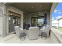 Relaxing covered porch with comfortable seating, an outdoor rug, and views of the lush surroundings at 17359 Wilkes Way, Westfield, IN 46074