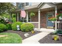 Inviting front porch with patriotic decor, landscaping and brick facade at 18278 Benton Oak Dr, Noblesville, IN 46062