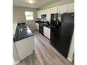Modern kitchen featuring white cabinets, black countertops, and stainless-steel appliances at 2717 N Rural St, Indianapolis, IN 46218