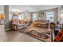Comfortable living room featuring laminate floors, neutral walls, two sofas, and a motorcycle-themed rug at 2730 Foxbriar Pl, Indianapolis, IN 46203