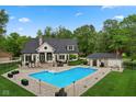 Back of home with a large in-ground pool surrounded by a patio and lush greenery, perfect for entertaining at 2953 Foxborough Dr, Greenwood, IN 46143