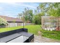 Backyard showing deck and greenhouse, with furniture at 305 W Vinyard St, Anderson, IN 46011