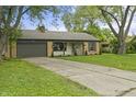 Charming brick home with an attached garage, a well-manicured lawn and tree lined driveway at 3526 Westfield Dr, Anderson, IN 46011