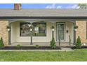 Inviting covered front porch featuring an overhang supported by columns and hanging flower baskets at 3526 Westfield Dr, Anderson, IN 46011