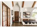 Inviting entryway with wood floors, beamed ceilings, seating, and a striking front door at 4435 E 38Th St, Indianapolis, IN 46218