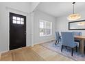 Bright dining room showcasing modern chandelier, wood table, blue upholstered chairs, and wood floors at 4681 Shelby Cir, Greenwood, IN 46143