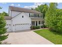 Charming two-story home featuring a three-car garage, front porch and manicured lawn at 4681 Shelby Cir, Greenwood, IN 46143
