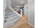A home staircase with soft gray carpet, leading into a bright living area with wood flooring at 4681 Shelby Cir, Greenwood, IN 46143