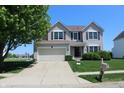 Two-story home with an attached garage, landscaping, and a view of the neighborhood at 5101 W Bay Rd, Plainfield, IN 46168