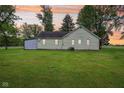 Green backyard featuring a home with well-maintained lawn and large shade trees at 6012 S 625 W, Pendleton, IN 46064