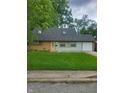 Charming single-story home with a well-manicured lawn and a bright yellow front door at 6117 Marilyn Rd, Indianapolis, IN 46226