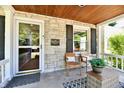 Inviting front porch with stone wall, chairs, and decor, perfect for relaxing outdoors at 6187 Crittenden Ave, Indianapolis, IN 46220