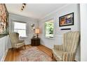 Cozy living room with wood floors, comfortable chairs, and natural light from multiple windows at 6187 Crittenden Ave, Indianapolis, IN 46220