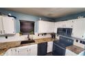 Bright kitchen with black appliances, contrasting countertops and sink window at 6637 Larkwood Ct, Indianapolis, IN 46241