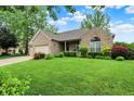 Beautiful single story brick house with a well maintained lawn and blue skies at 7310 Monaghan Ln, Indianapolis, IN 46217