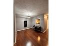 Bright dining room with hardwood floors, minimalist table set, and a pass-through window to kitchen at 7601 Newport Bay Dr # 203, Indianapolis, IN 46240