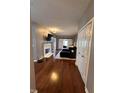 Open-concept living room with fireplace, dark blue sectional, hardwood floors, and sliding barn doors at 7601 Newport Bay Dr # 203, Indianapolis, IN 46240