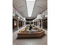 Bright lobby featuring a central water feature, skylights, and second-story balconies at 7601 Newport Bay Dr # 203, Indianapolis, IN 46240
