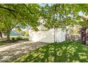 Two-car garage with green lawn, framed by large tree, and easy driveway access at 7650 Micawber Ct, Indianapolis, IN 46256
