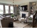 Inviting living room with gray sectional couch, modern fireplace, and a decorative chandelier at 8876 Boylan Pl, Pendleton, IN 46064