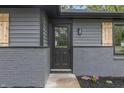 Close-up of the front door with a glass insert, stylish light fixture, and decorative wood shutters at 8933 W 1050 S, Fortville, IN 46040