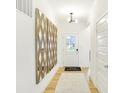 Inviting hallway with hardwood floors and a decorative mirror leading to the main living area at 9351 Abner St, McCordsville, IN 46055